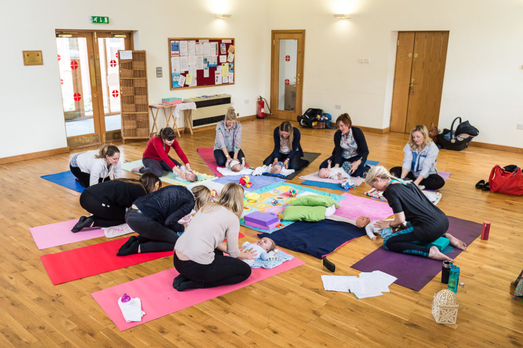 parents learning the benefits of baby yoga in a baby yoga class