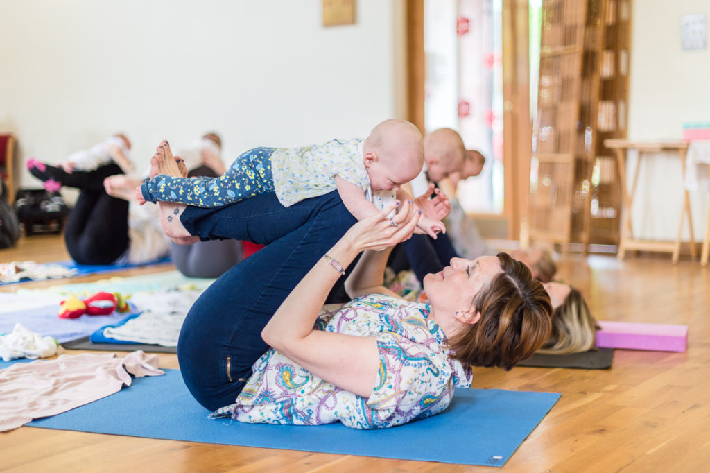 benefits of baby yoga as mum balances a baby on her legs