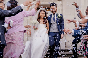 guests shower a bride and groom with confetti on the steps of London's Marylebone Town Hall