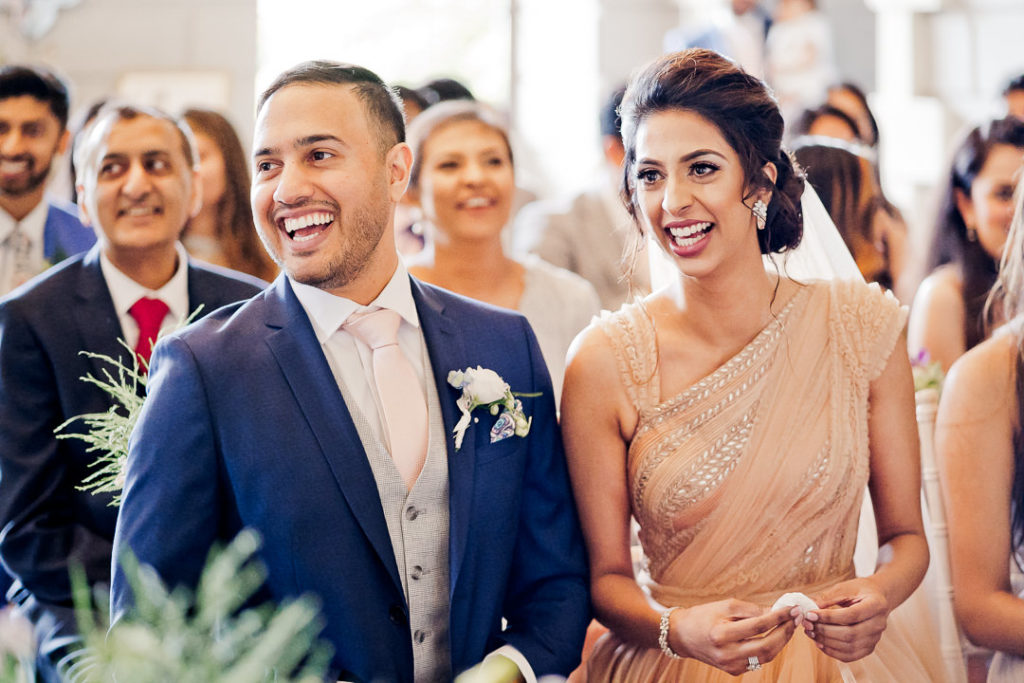 bride and groom laugh at the best mans reading during their wedding ceremony