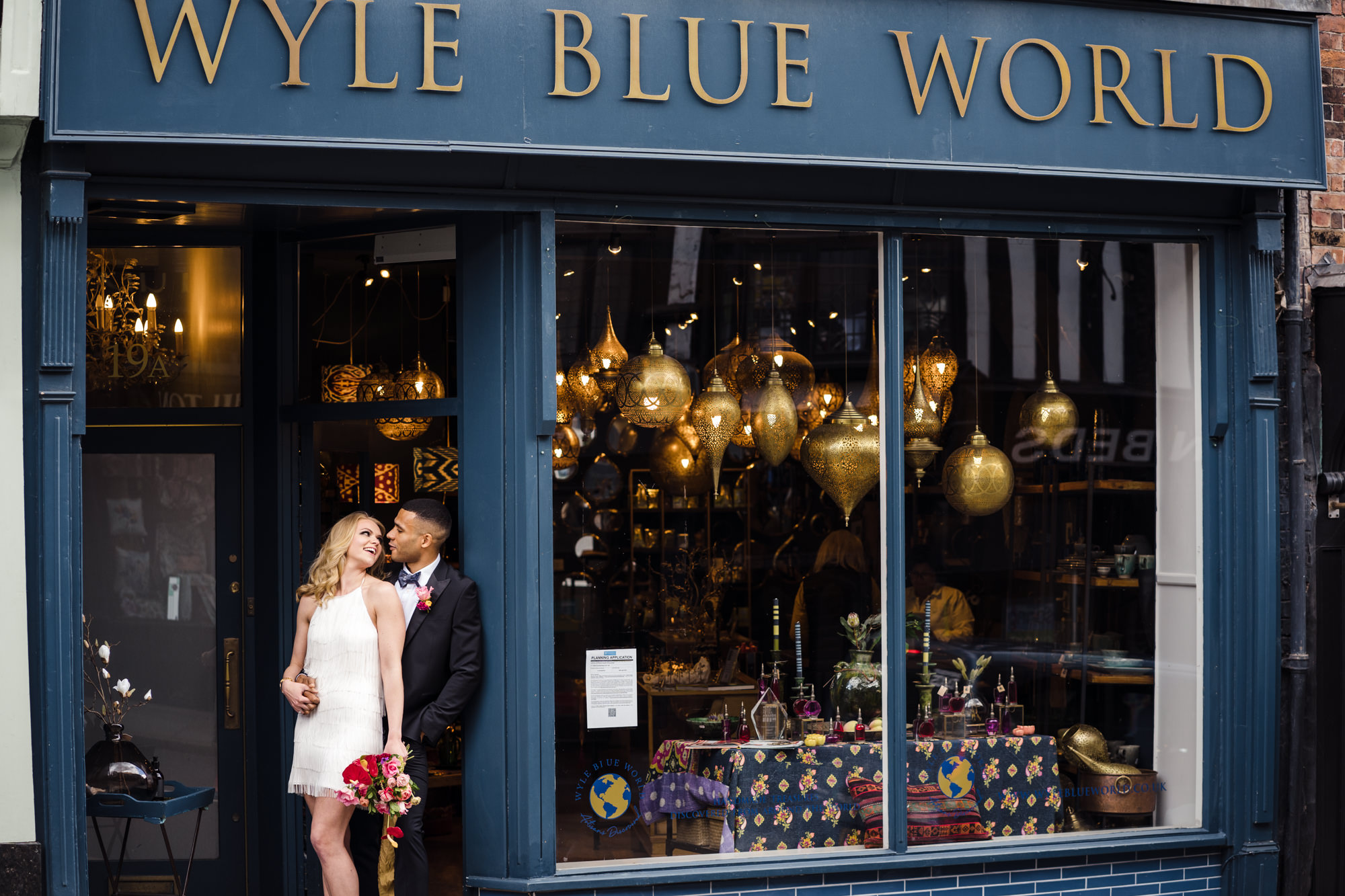 bride and groom stand hugging in the door way of wyle blue world in shrewsbury