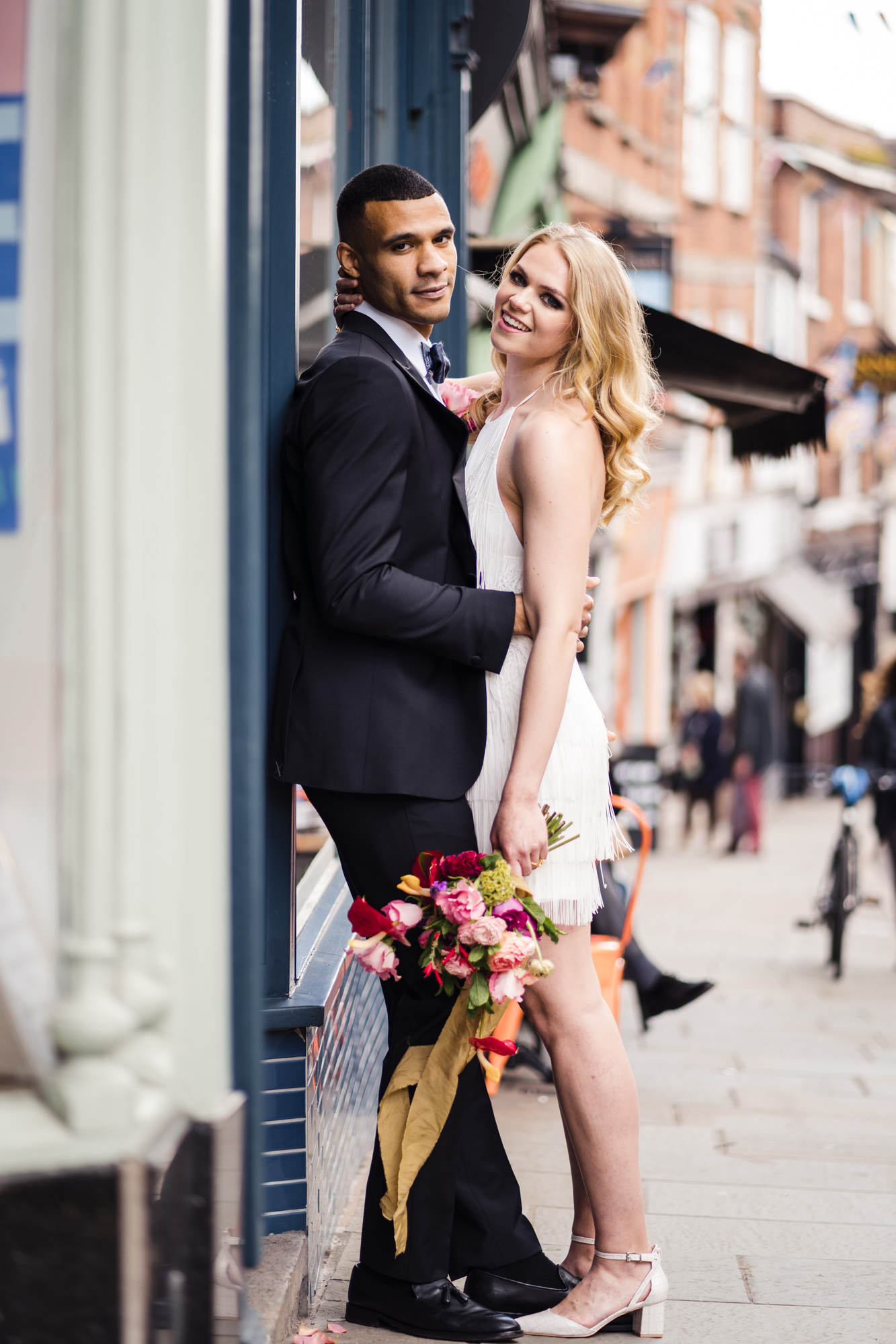 urban couple photo as bride and groom stand on city street