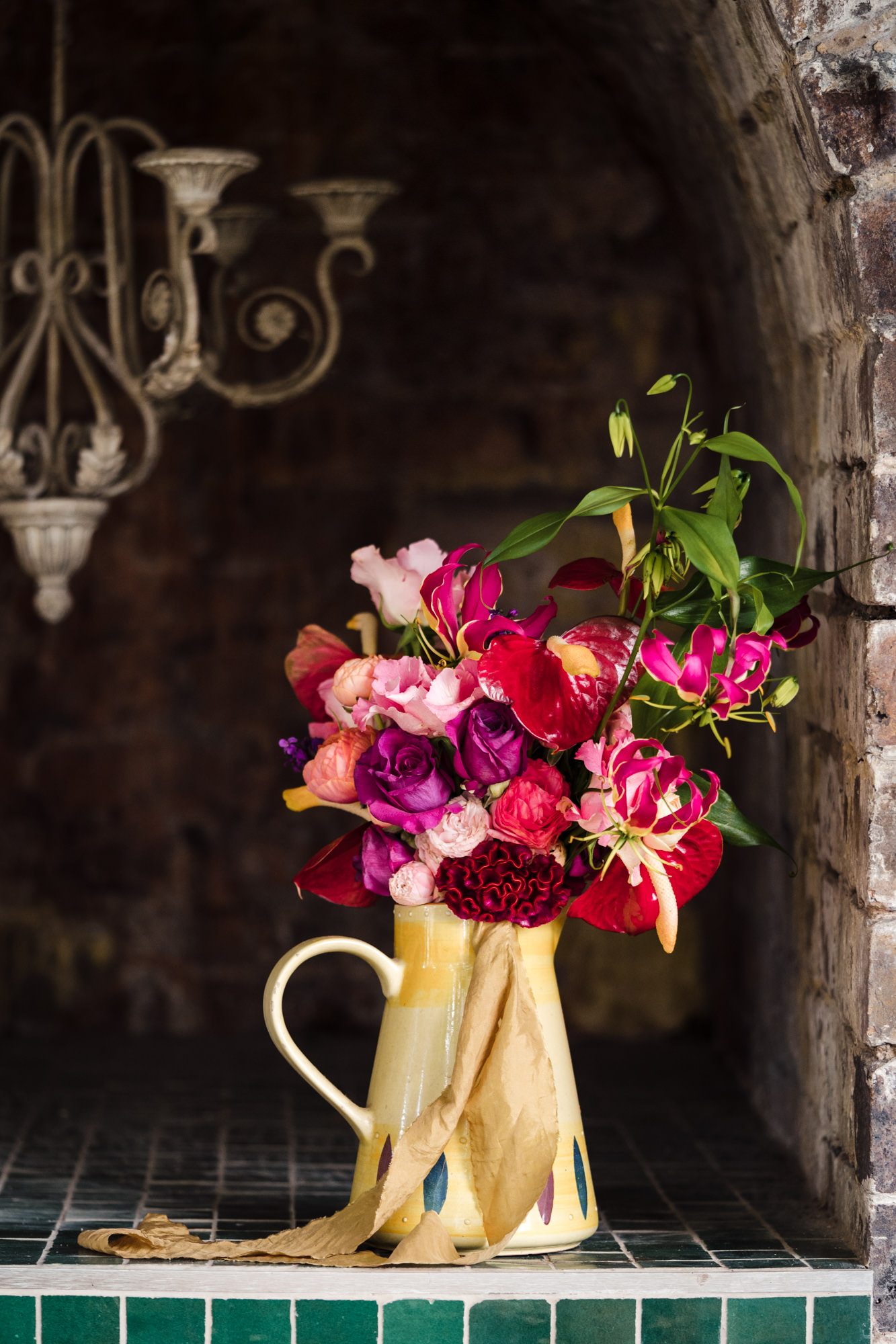 bold colourful wedding bouquet sitting in a yellow jug
