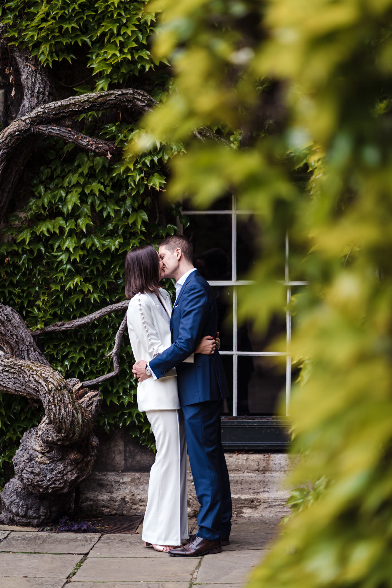 bride and groom kiss in the grounds of lincoln college oxford for their elopement city wedding