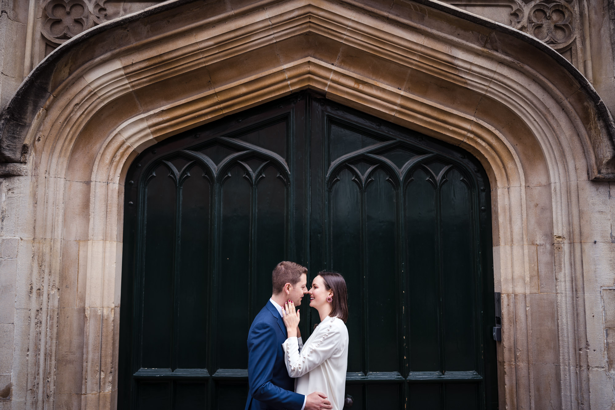 bride and groom pose for couple portrait in front of large green door