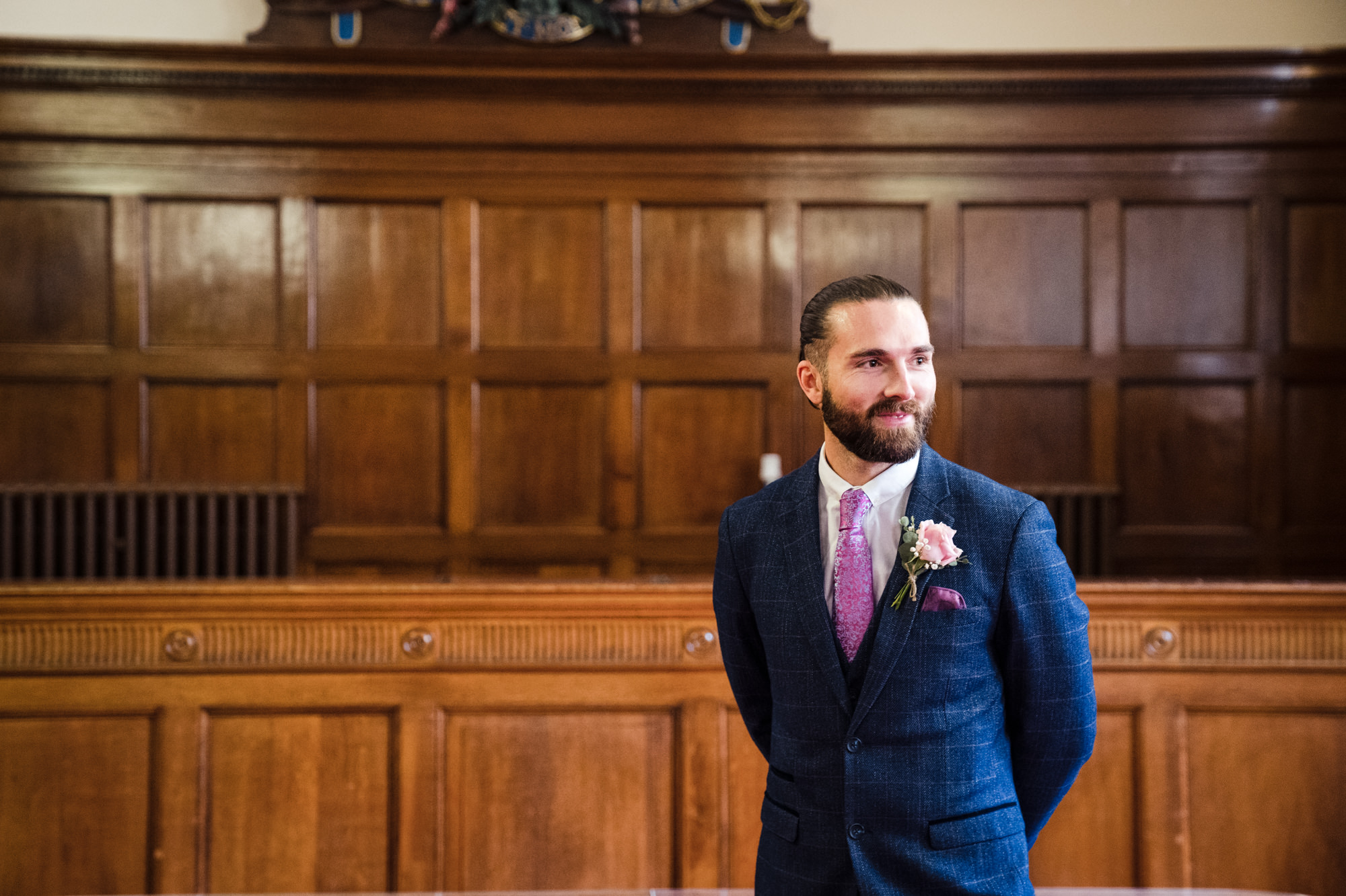 groom waits inside ceremony room at bath guildhall looking over at guests