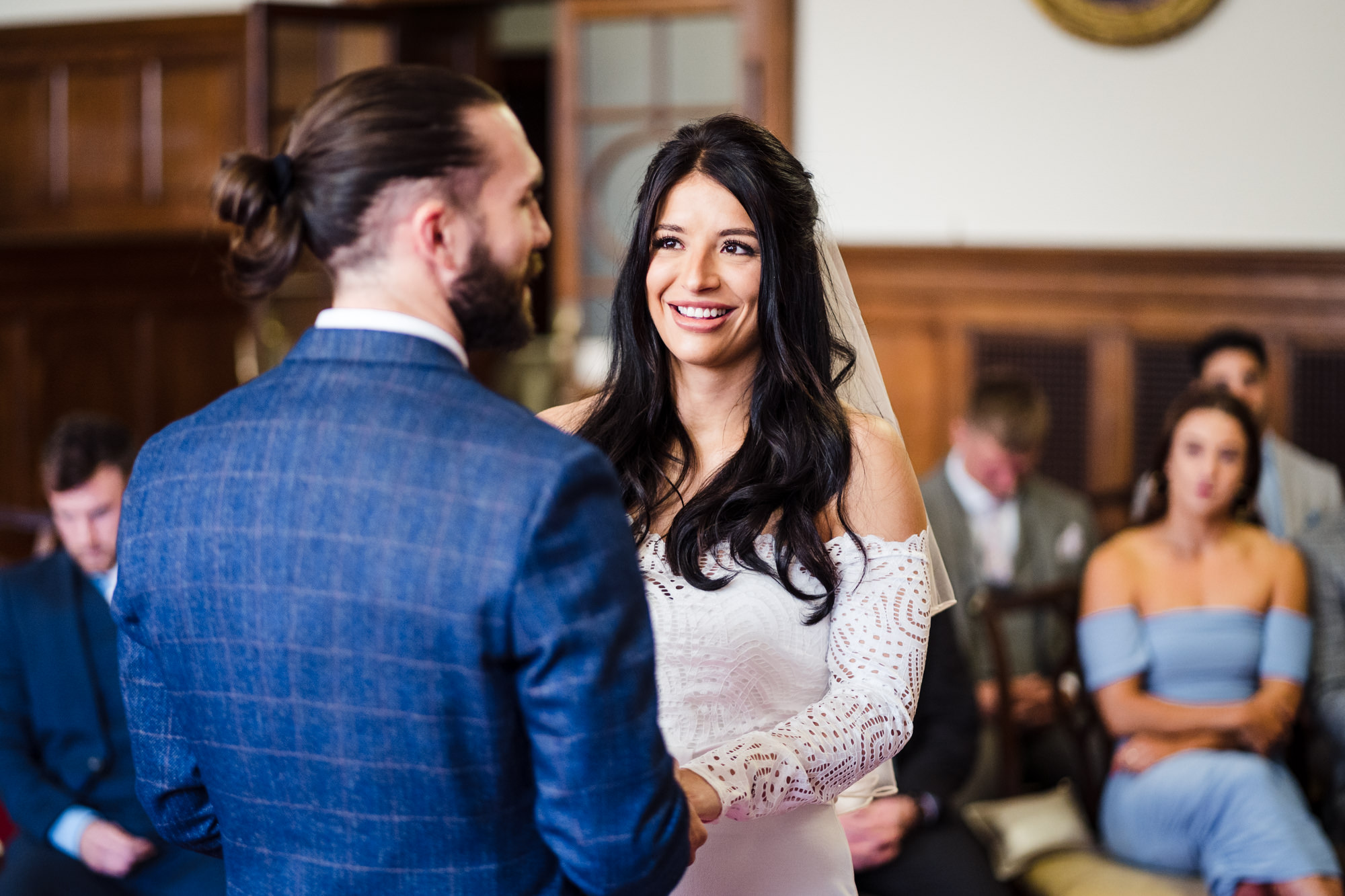 bride smiles and looks at groom during wedding ceremony at bath city guildhall