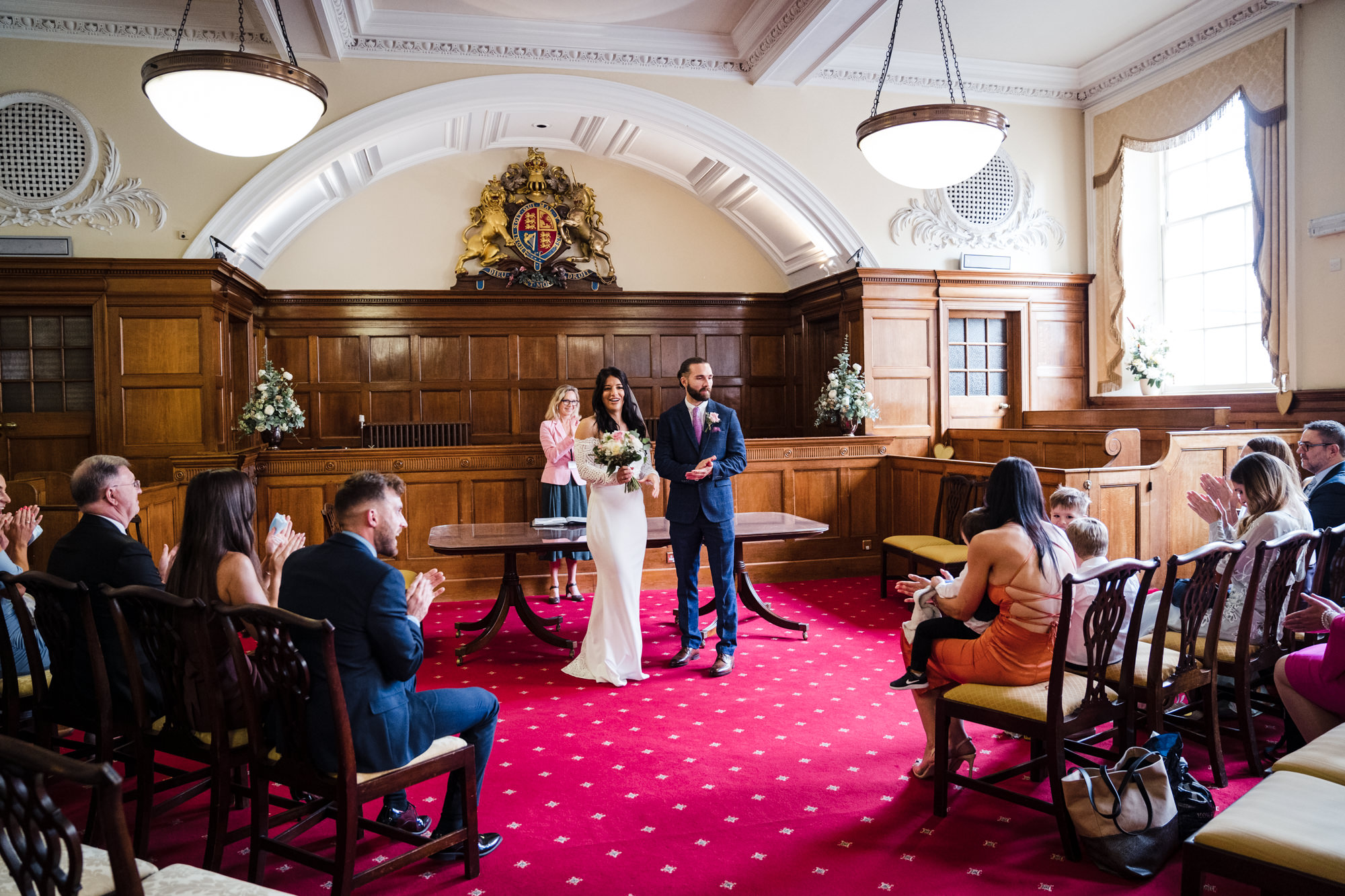 guests clap and celebrate their marriage in the ceremony room at bath guildhall