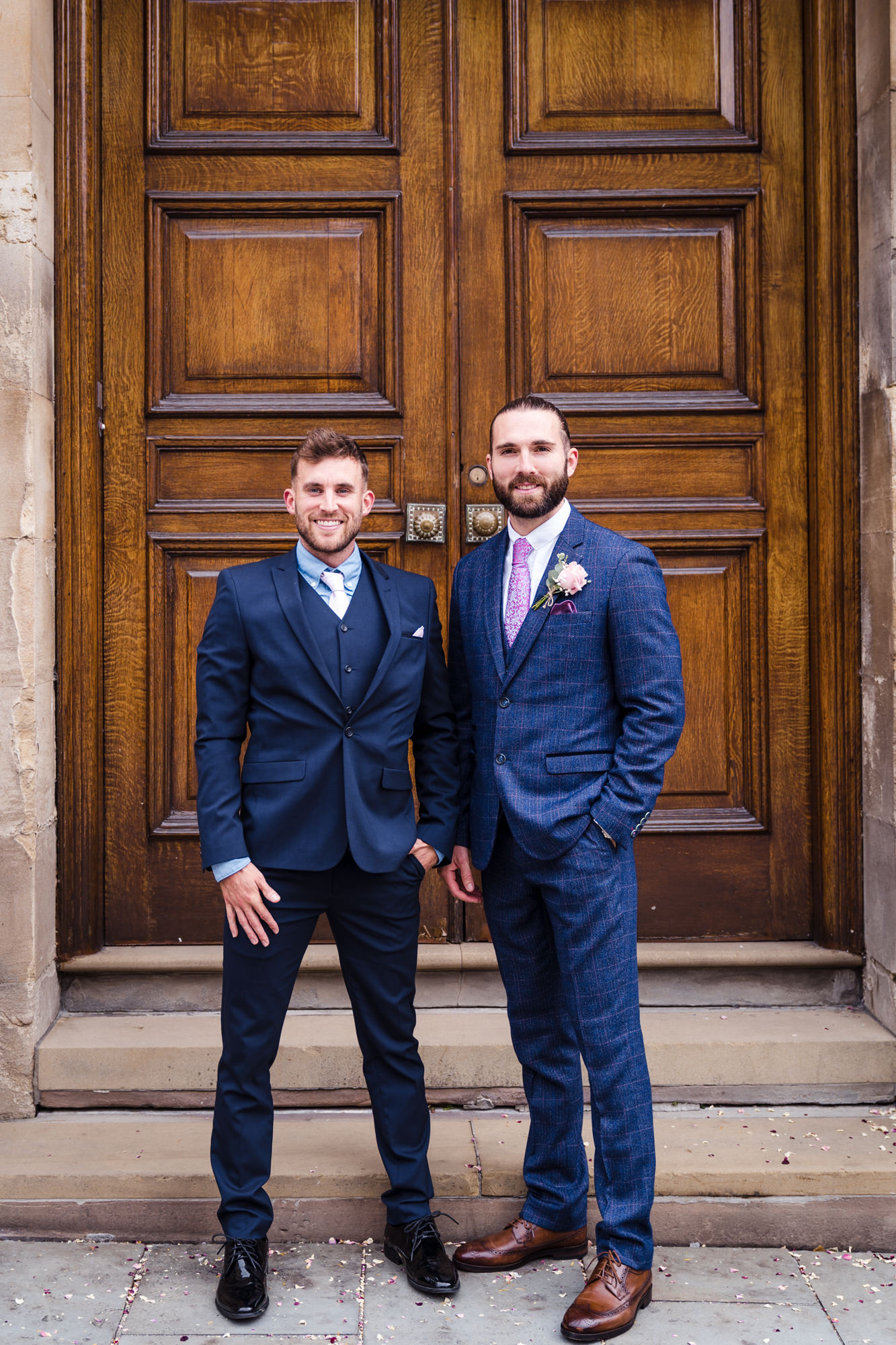 groom and best man stand for a wedding photo outside his city wedding