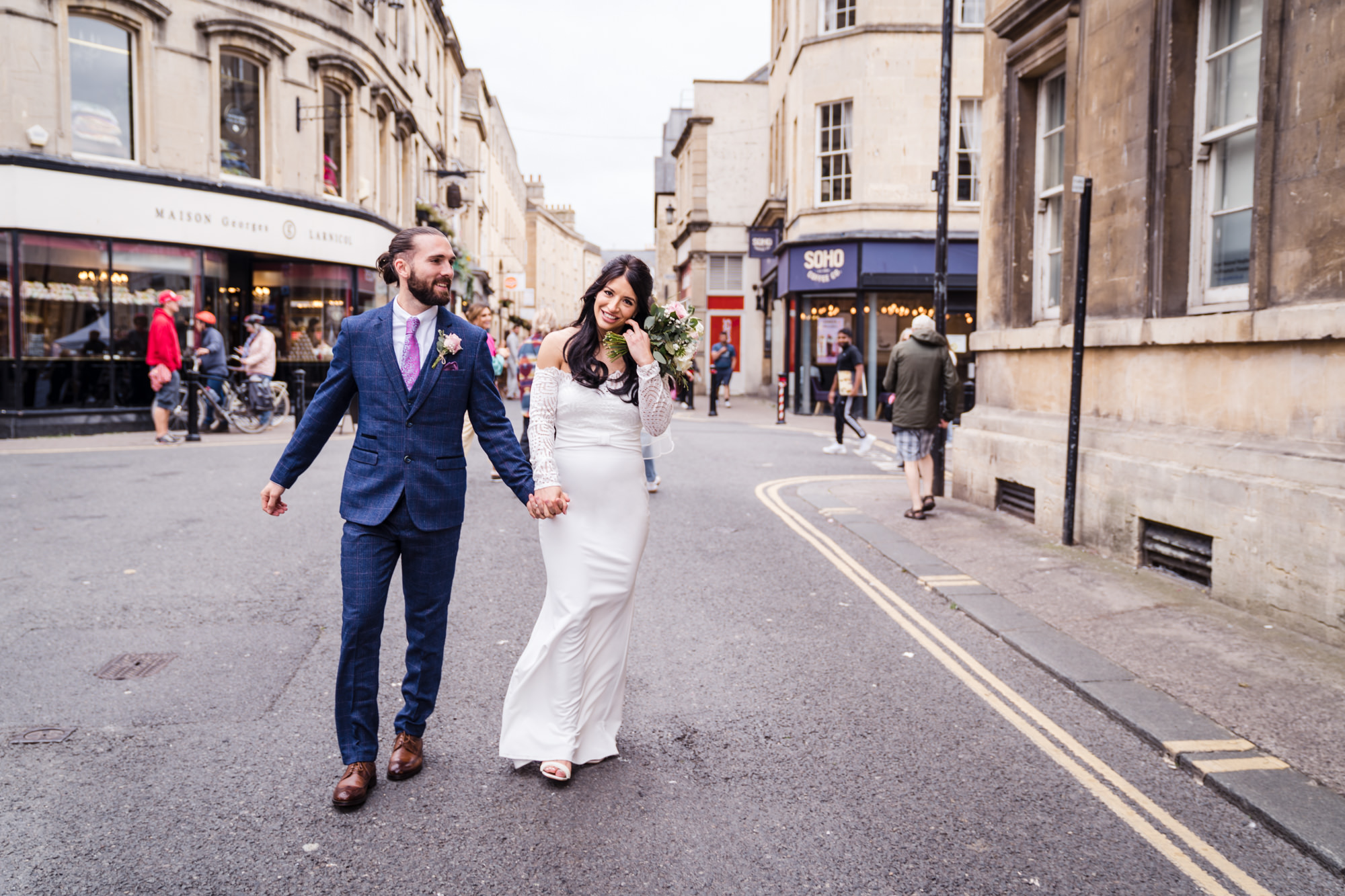 relaxed married couple walk through the city centre of bath
