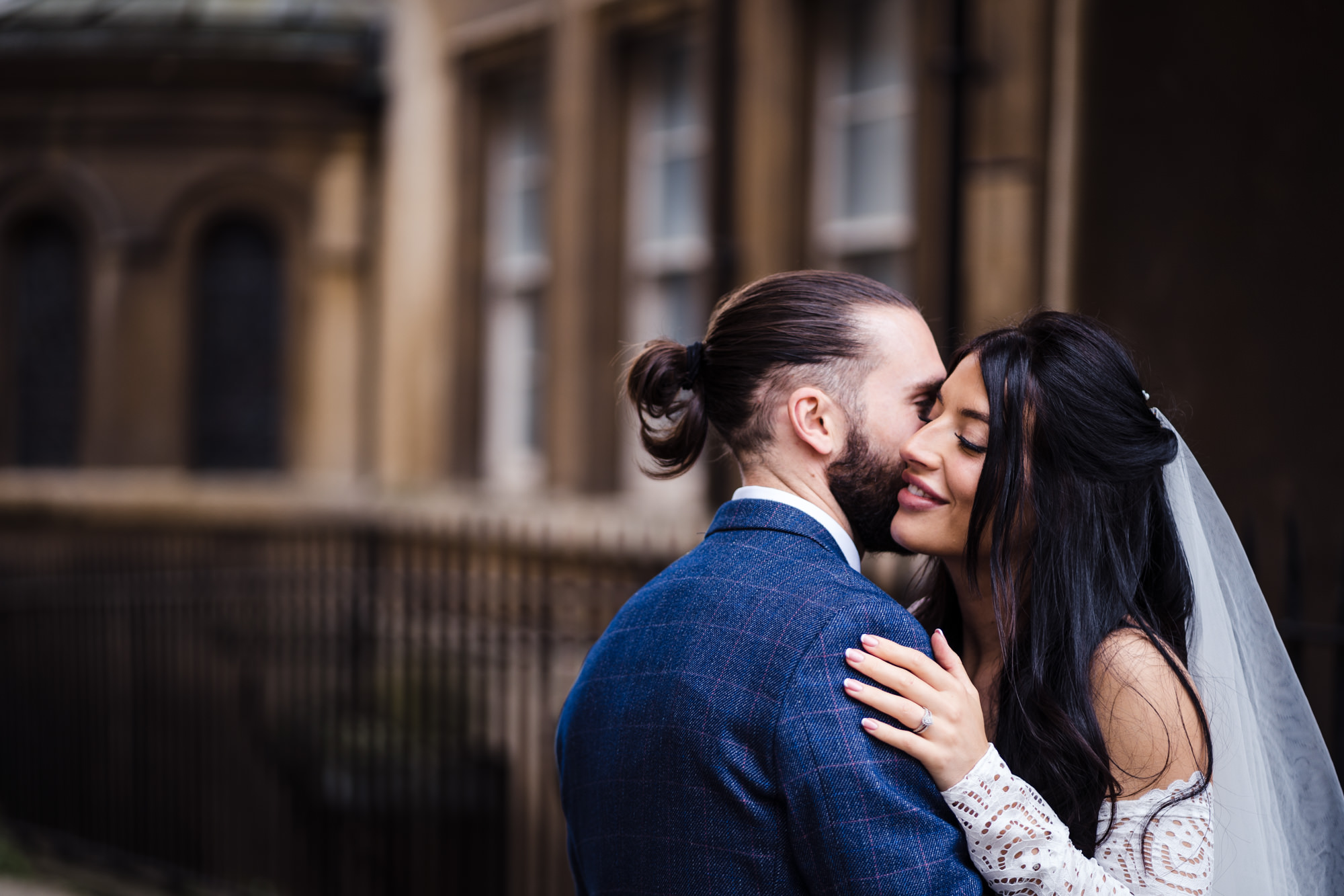 bride and groom embrace for wedding photo in city centre