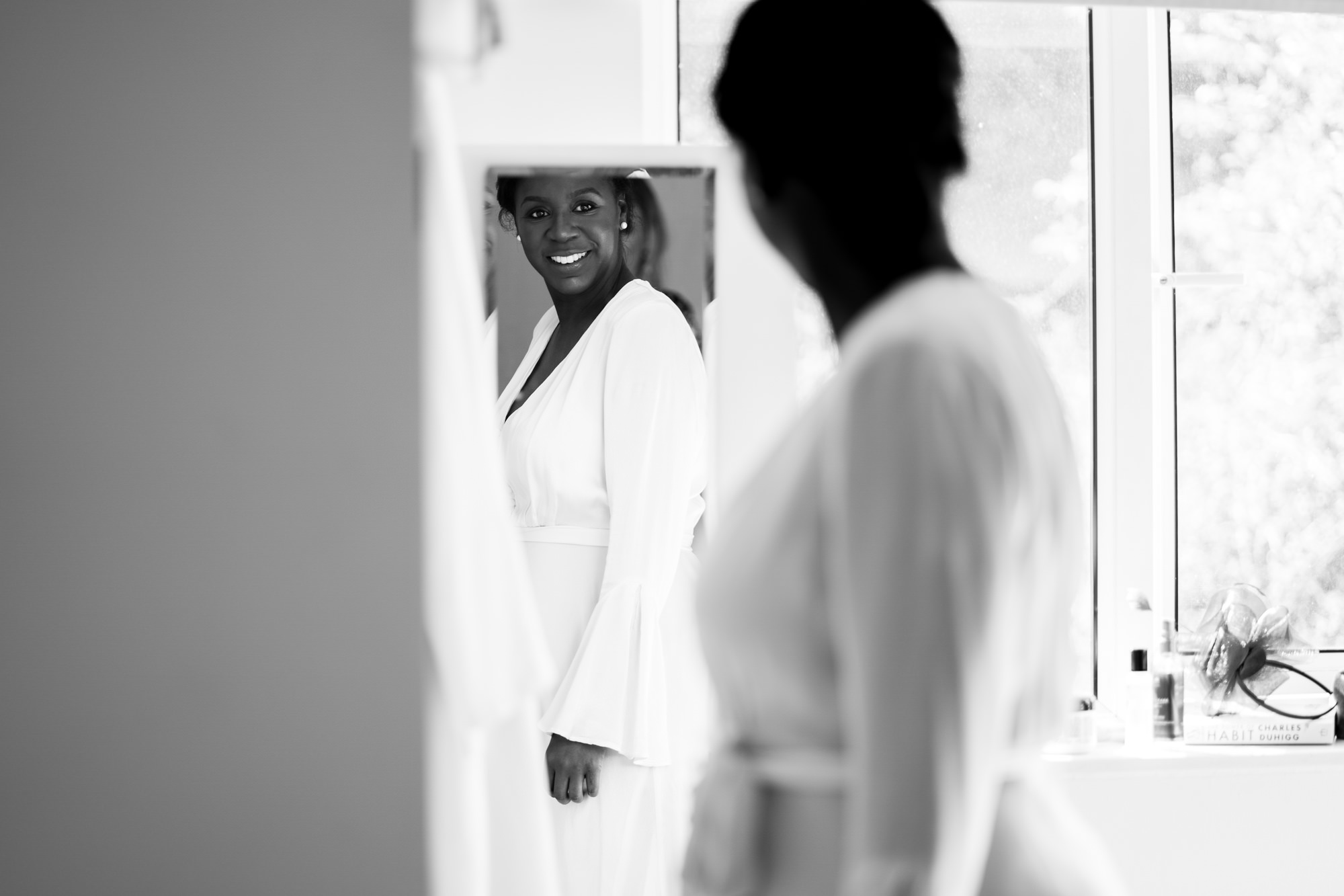 bride looks at herself in the mirror while wearing her wedding dress
