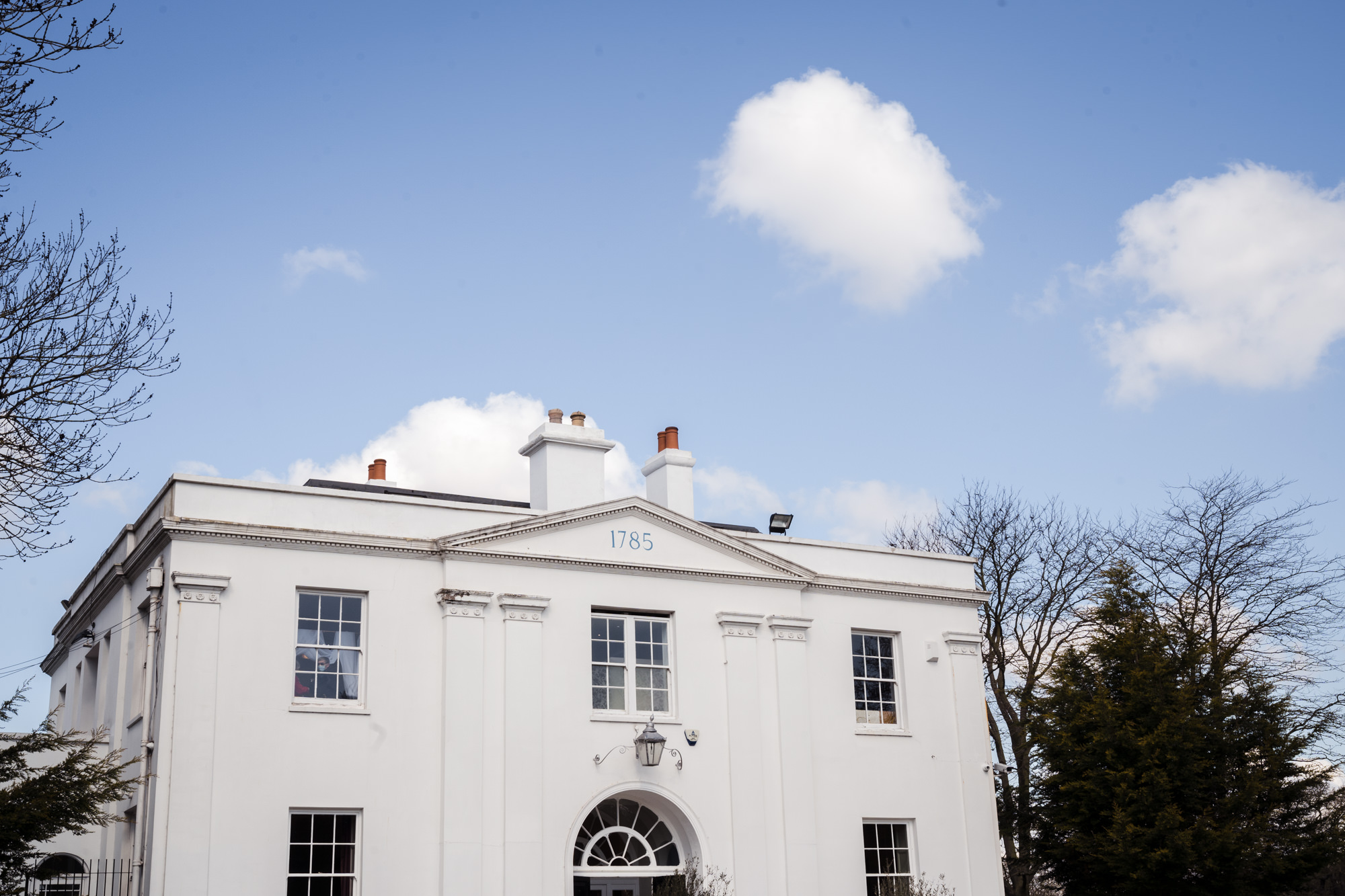 wide photograph of wedding venue Belair house in south london with a blue sky