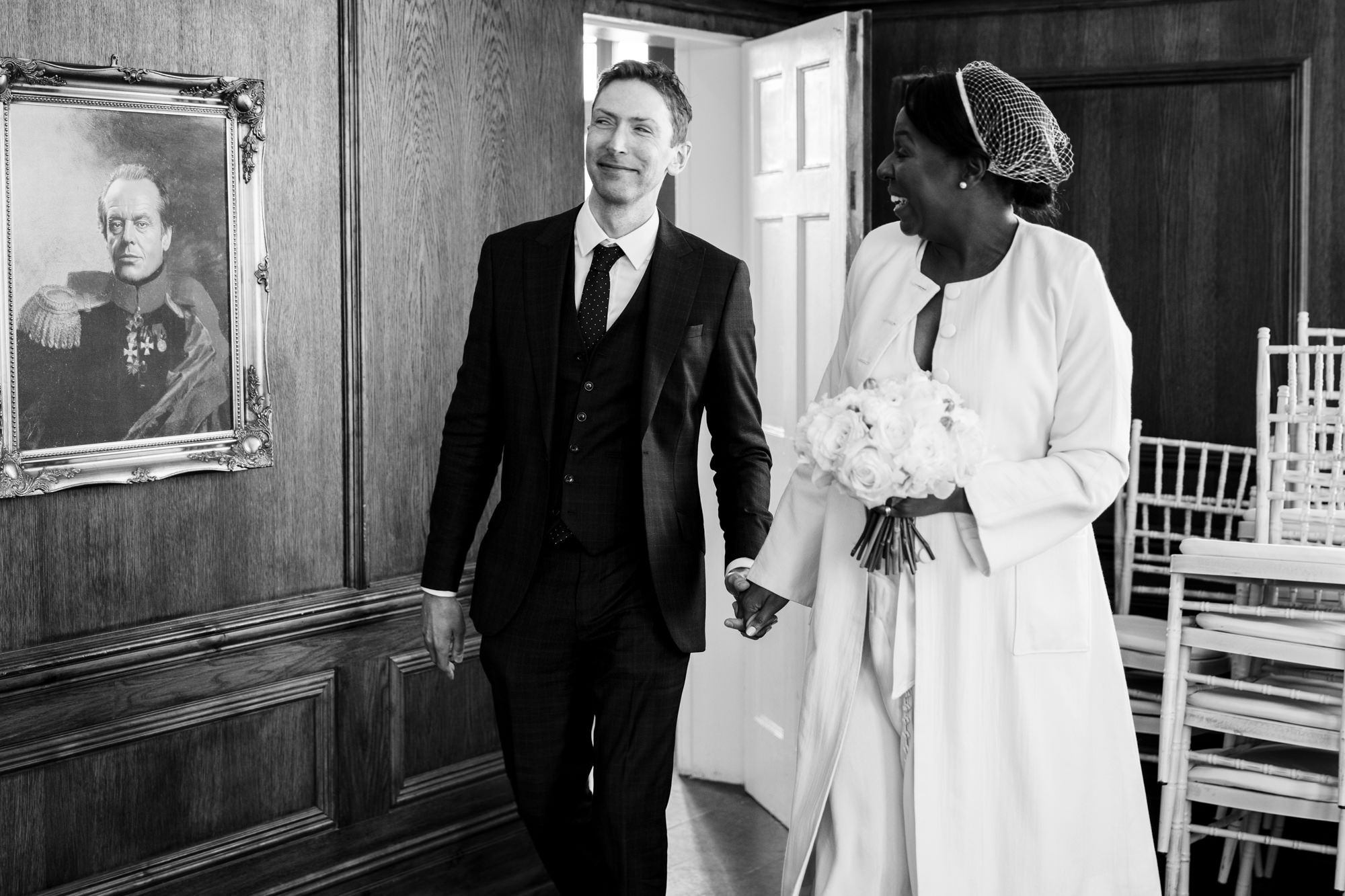 bride and groom walk out of their ceremony holding hands and smiling