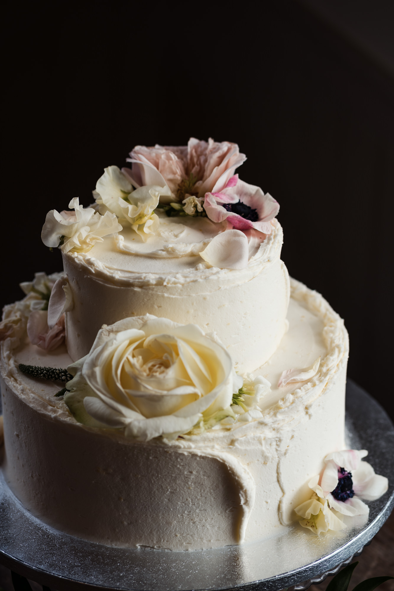 close up of flowers decorated on a two tier white wedding cake from london's Violet Cakes By Claire Ptak