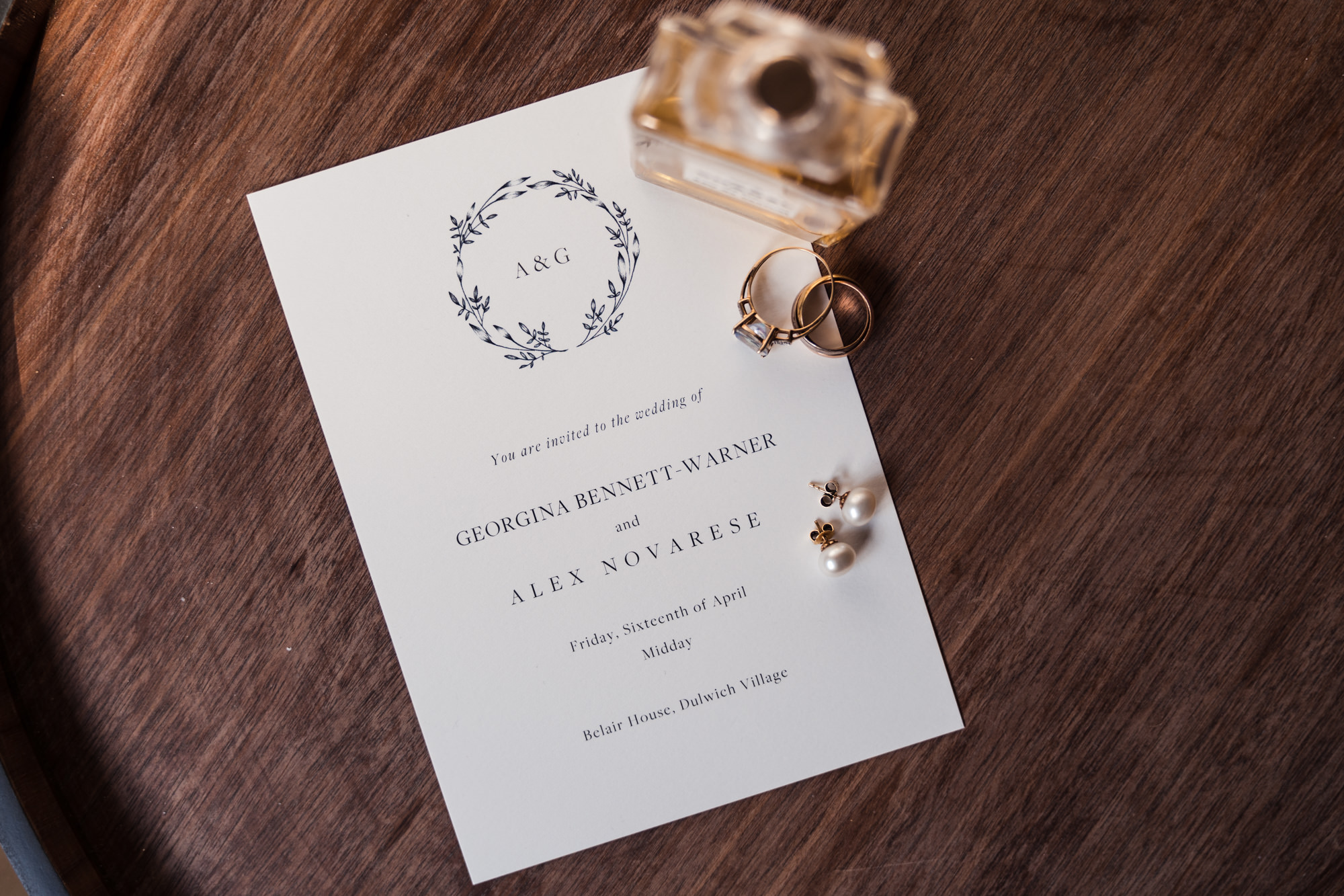 photograph of bride and grooms wedding invite decorated with a perfume bottle and vintage rings