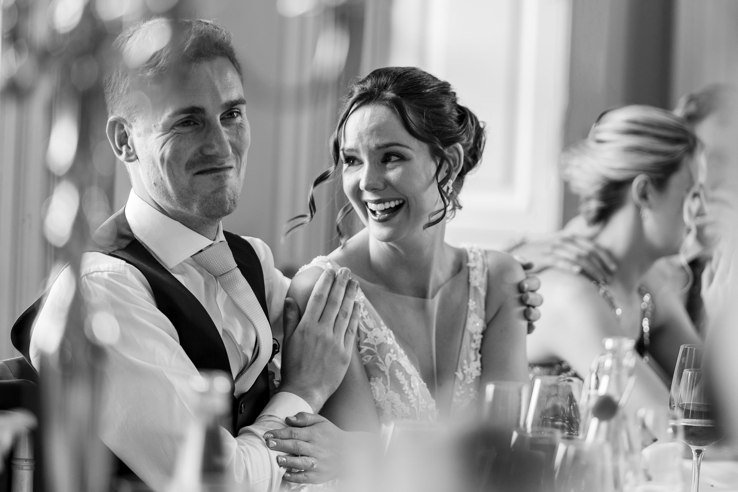 How to choose a wedding photographer who captures genuine emotion - bride and groom smiling during speeches