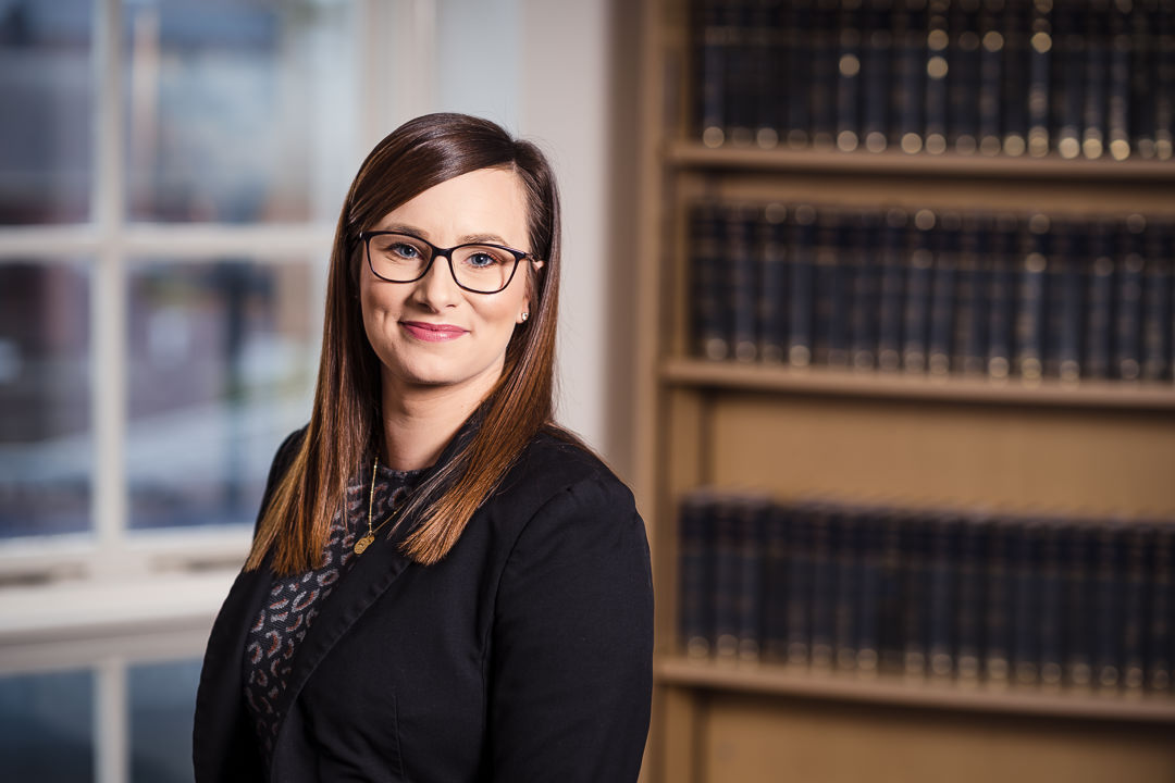 Approachable solicitor headshot in Shrewsbury office with law library backdrop