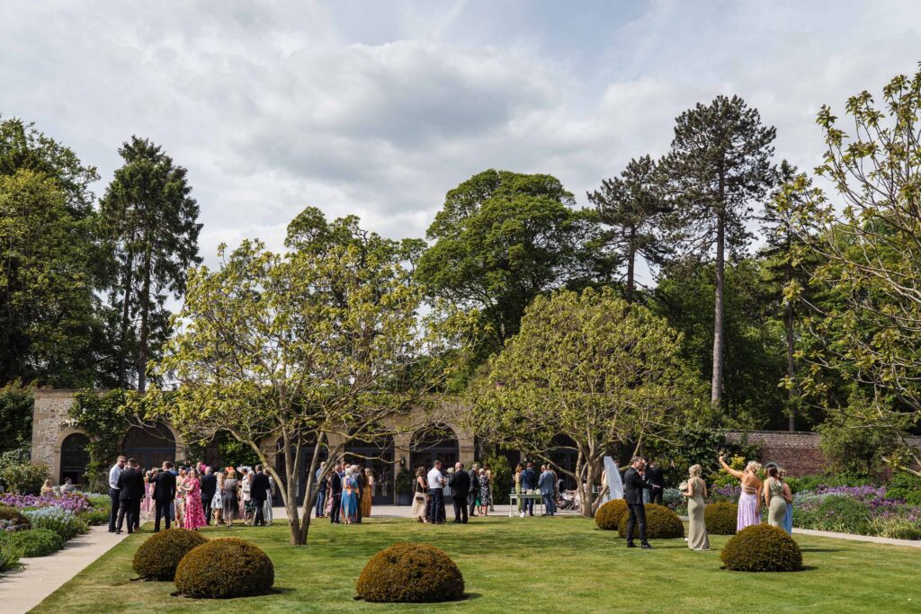 Guests mingling during the drinks reception on the lawn outside Middleton Lodge’s orangery.